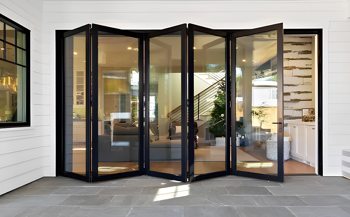Black Frame Multi-panel Folding Glass Door Transitioning Interior Living Area to Deck Black Frame Multi-panel Folding Glass Door Transitioning Interior Living Area to Deck