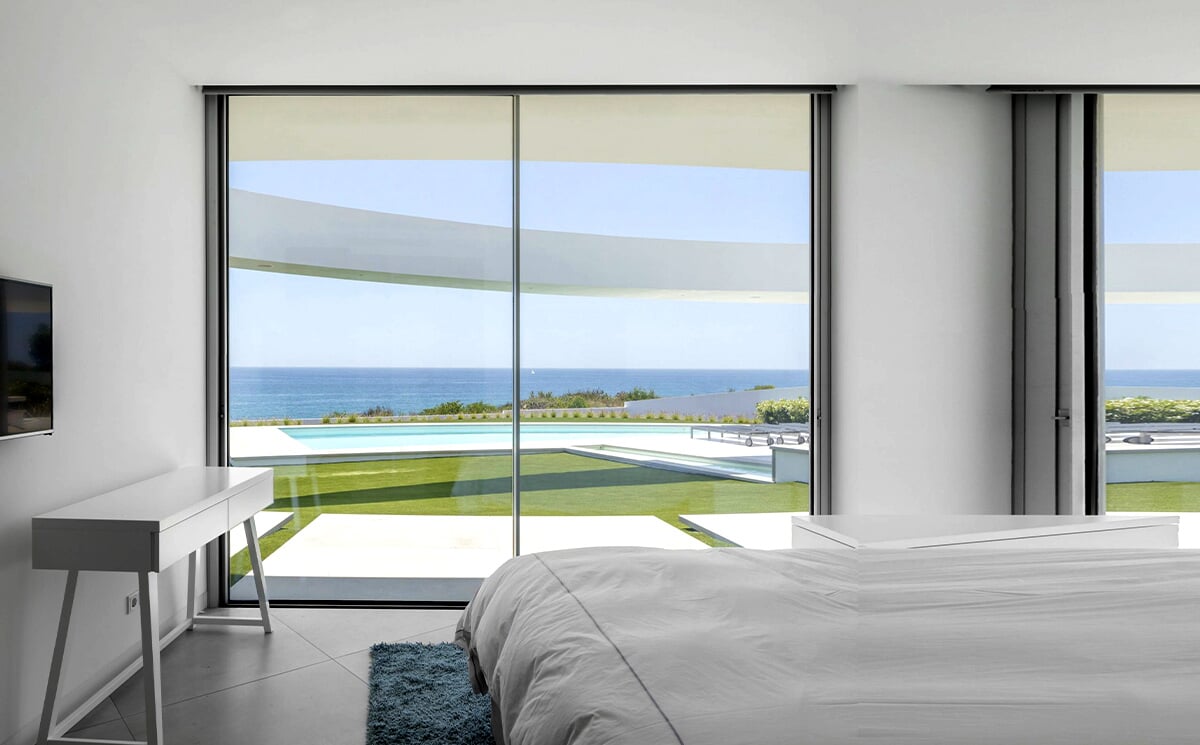Panoramic Living Room Facing Outdoor Greenery Through Large Glass Wall Panoramic Living Room Facing Outdoor Greenery Through Large Glass Wall
