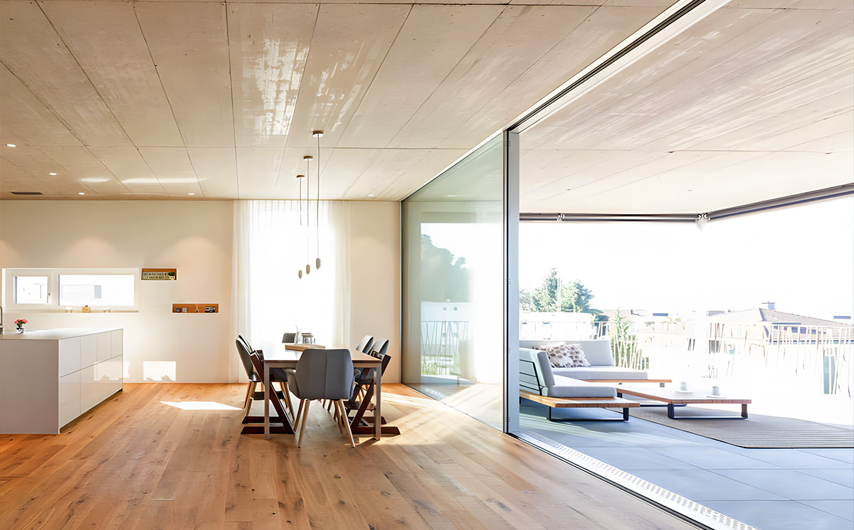 Flush track minimal frame sliding door seamlessly connecting indoor living room and outdoor patio Flush track minimal frame sliding door seamlessly connecting indoor living room and outdoor patio