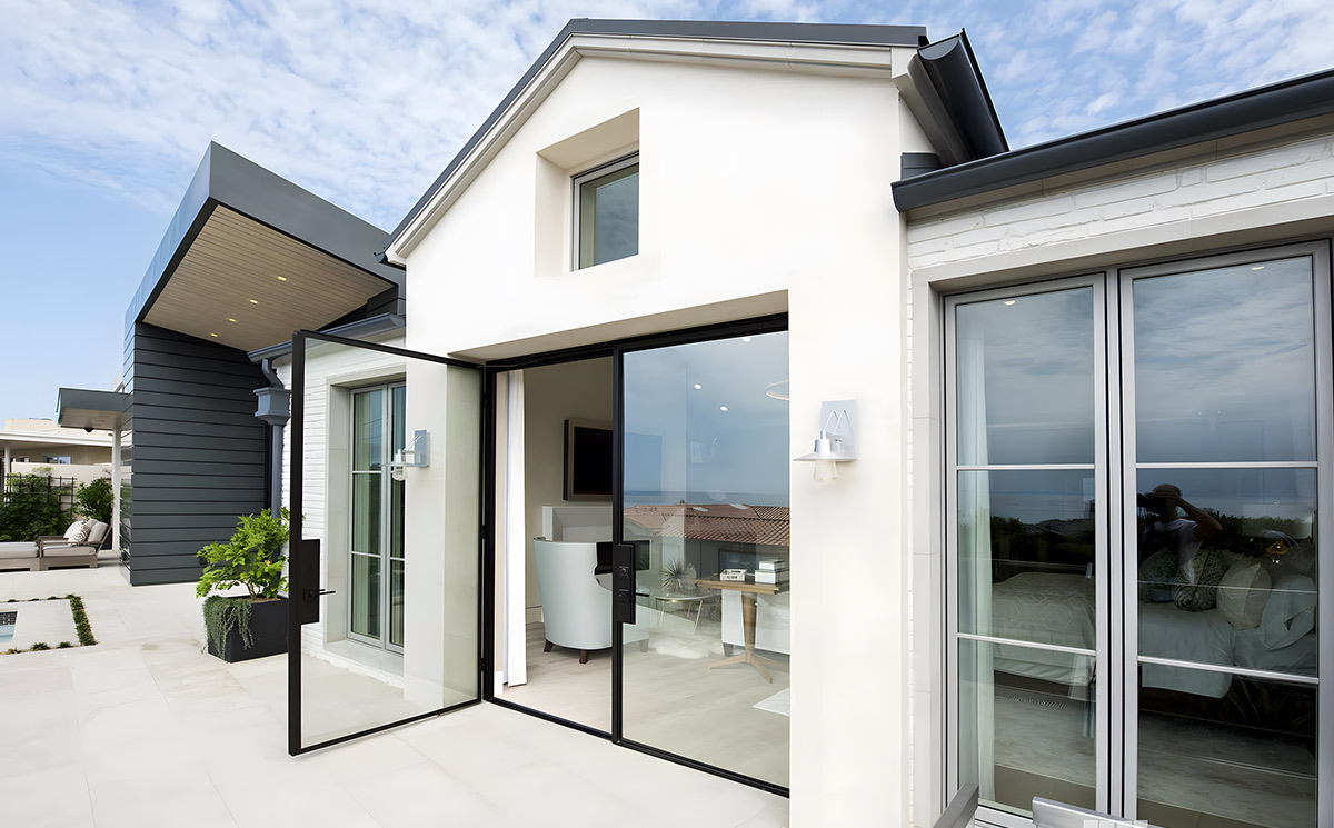 Exterior slim aluminium French patio doors with large clear glass panel opening onto a modern outdoor pool terrace Exterior slim aluminium French patio doors with large clear glass panel opening onto a modern outdoor pool terrace