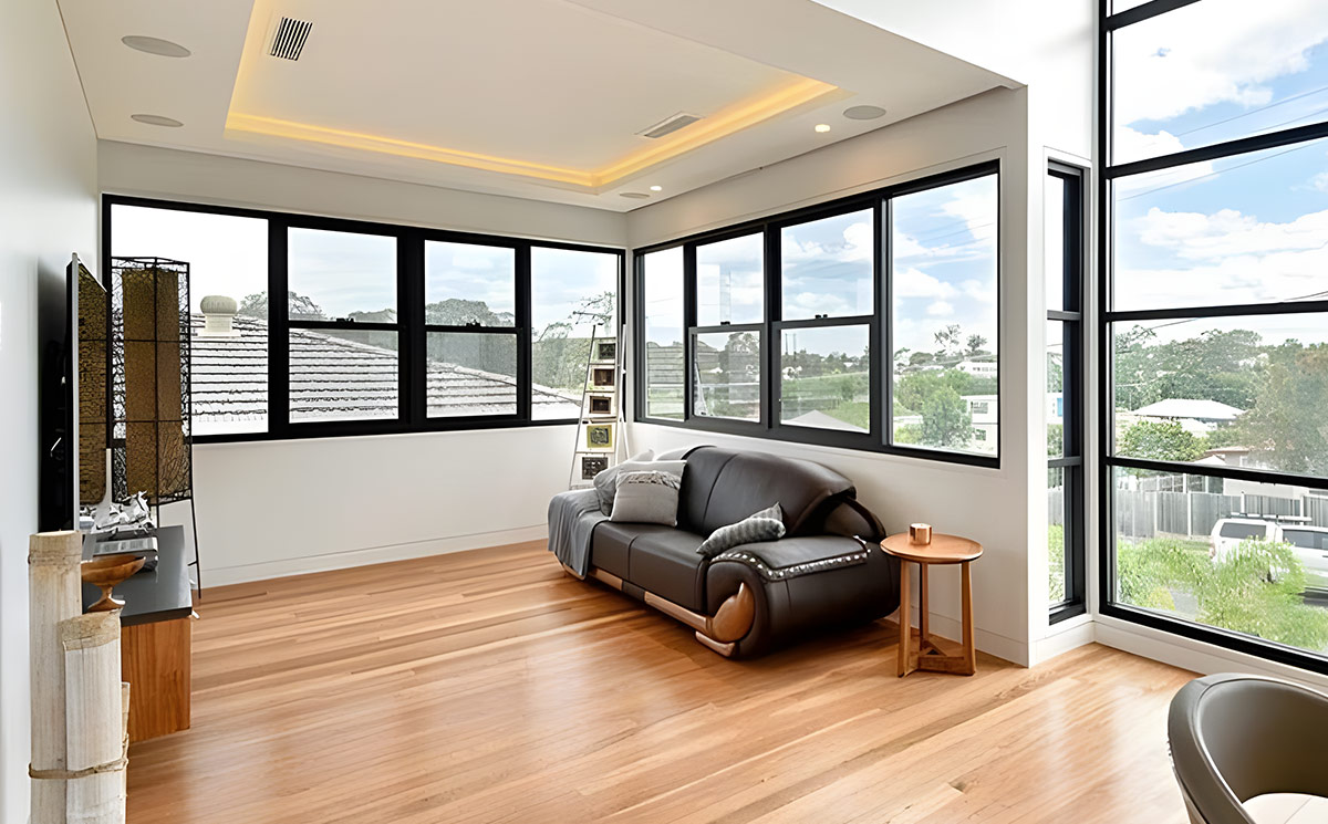 Modern black frame double hung aluminum windows installed in an open-concept living room